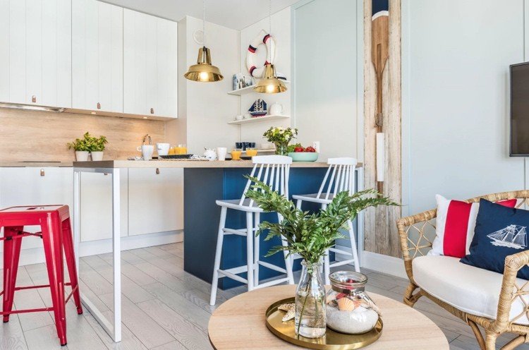 Ikea -kök med vita fronter och trävägg i kombination med mörkblå ö för ett vackert marint utseende