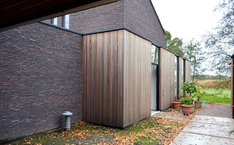modern-klinker-fasad-trä-golv till tak-terrass-dörrar-trädgård-egendom