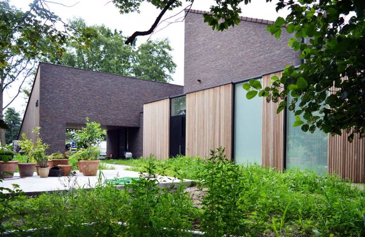 modern-klinker-fasad-altandörrar-trä-trädgård-växt-fönster