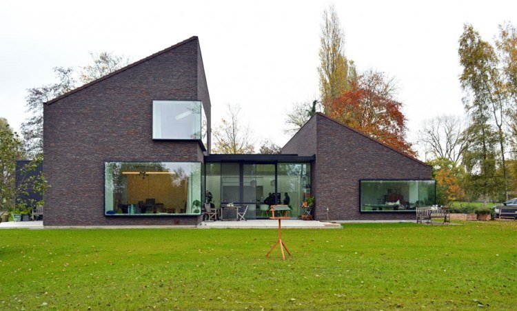 Modern klinkerfasad-enfamiljshus-panoramafönster-ljus-tomt-gräsmatta