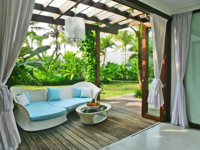 designer-soffa-soffbord-vita-krökta-linjer-vita-gardiner-trädgård
