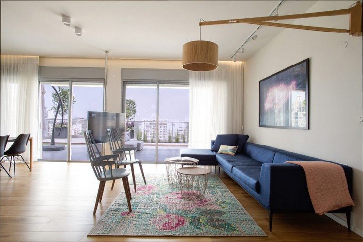 vardagsrum-blå-soffa-hängande-lampa-trä-terrass-gardiner-utsikt