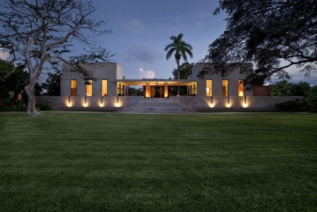 Symmetrisk hacienda, vidöppen front, platt takkonstruktion, gräsmattbelysning