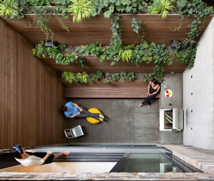 Terrassdesign-innergård-betong-kakel-utomhus-grill-trä-bänk-upphöjda sängar-växter