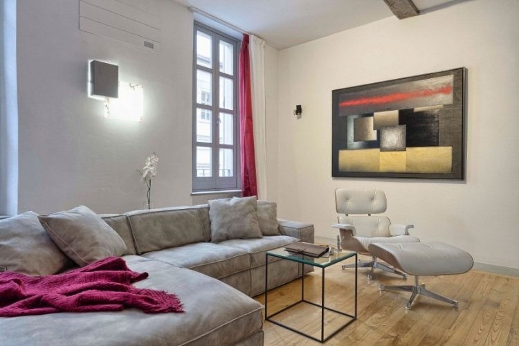 Modern lägenhet-vardagsrum-trägolv-vit-vägg-röd-accenter