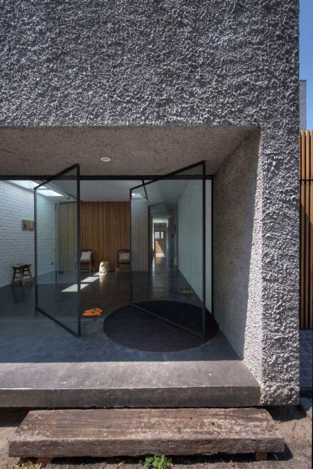 modernt hus naturmaterial glas svängdörrar betong