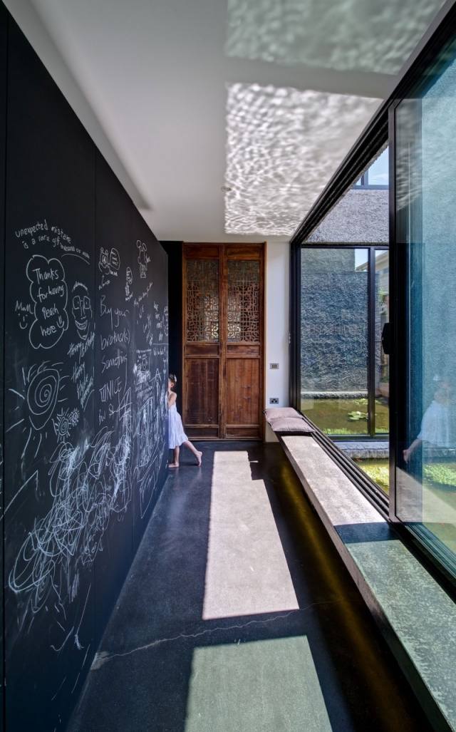 modernt familjehus interiör solljus svart tavla måla vägg