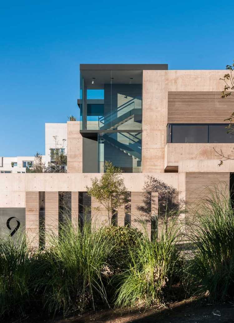 modernt enfamiljshus fasad färgade-exponerade-betong-paneler-dekorativt glas