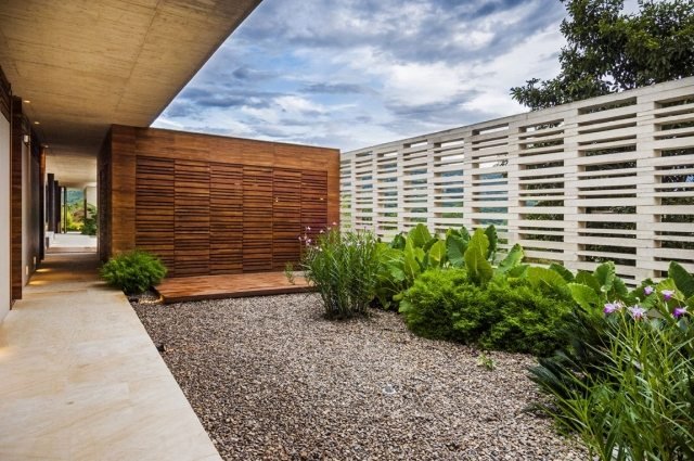 Landskapsarkitektur-modern-betong-vägg-utskärningar-trä vägg-grus-golv