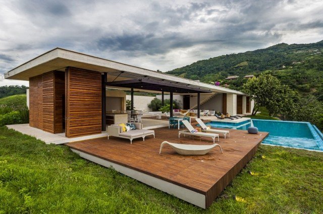 envåningshus-modern-trä-terrass-pool-solstolar