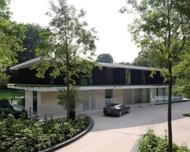 modernt hus platt tak entré skog landskap välskött trädgård