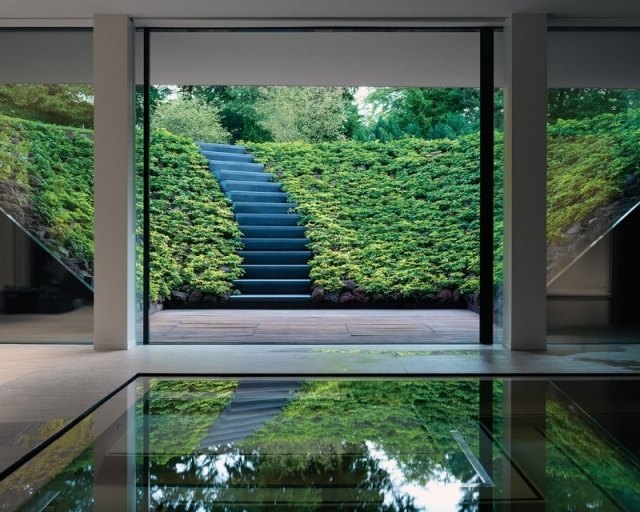 modernt enfamiljshus glasväggar natur inbjuder trappor