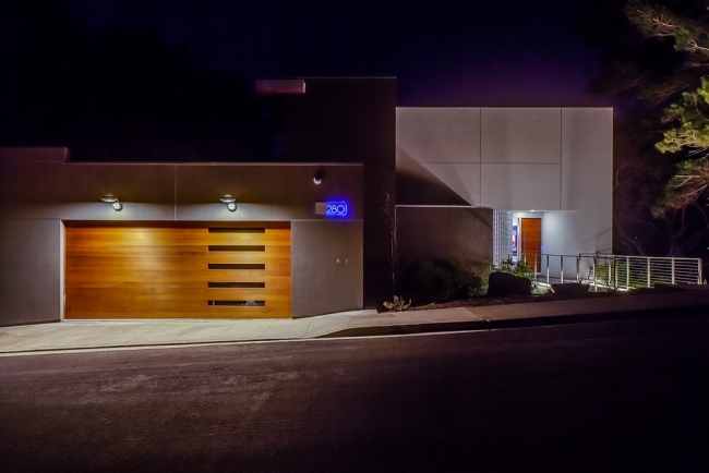 modernt hus trä garageport glaselement belysning