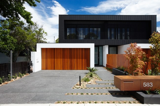 modern trä garageport svart golv fasad landskapsarkitektur