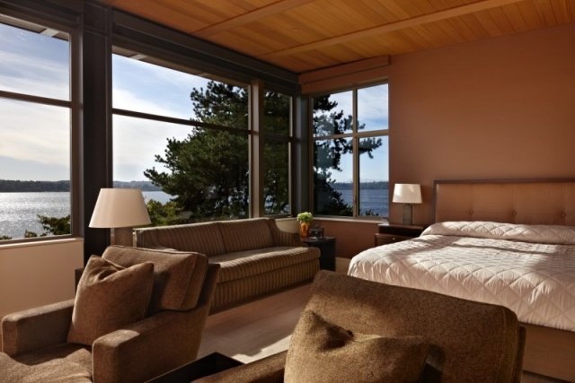 modernt sovrum trätak stora fönster bank utsikt