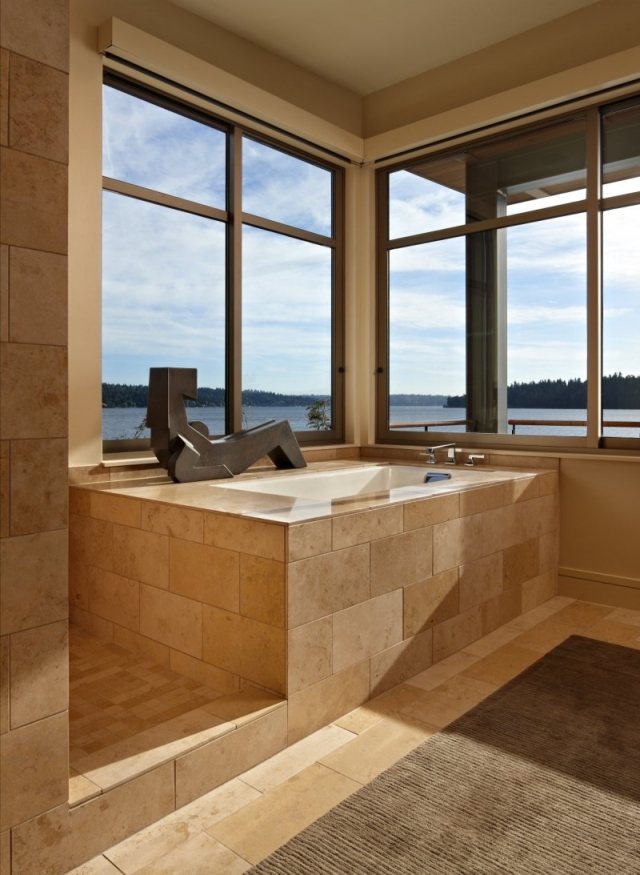 badrum badkar hörn beige kakel stora fönster