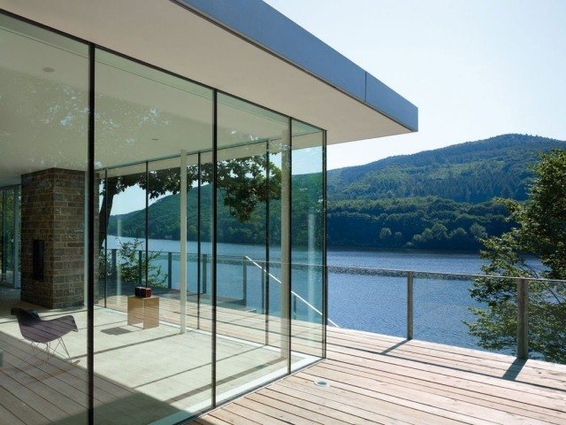 modernt hus-sjö-glas-vägg-dagsljus-interiör-panoramautsikt