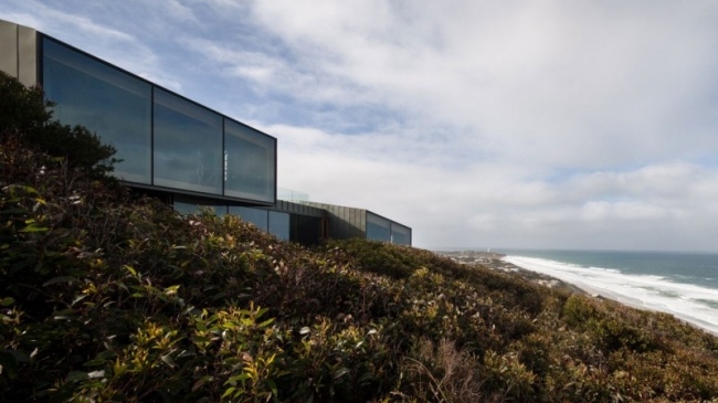 Strandhus geometrisk glasfront Fairhaven fasaddesign - modern asymmetrisk form