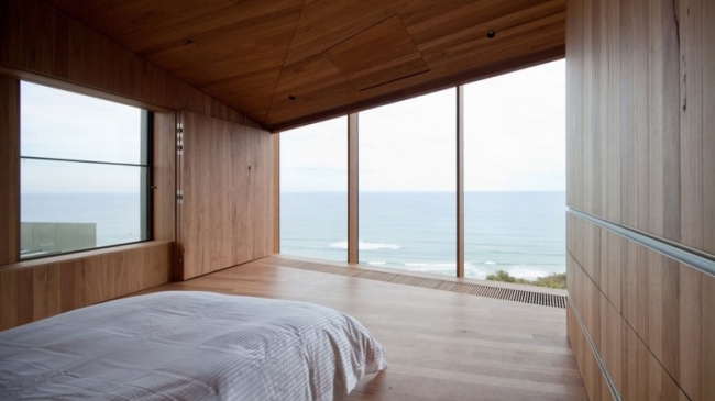 Sovrum med snett tak, panoramautsikt över glasvägg, träbeklädnad, helt enkelt puristisk