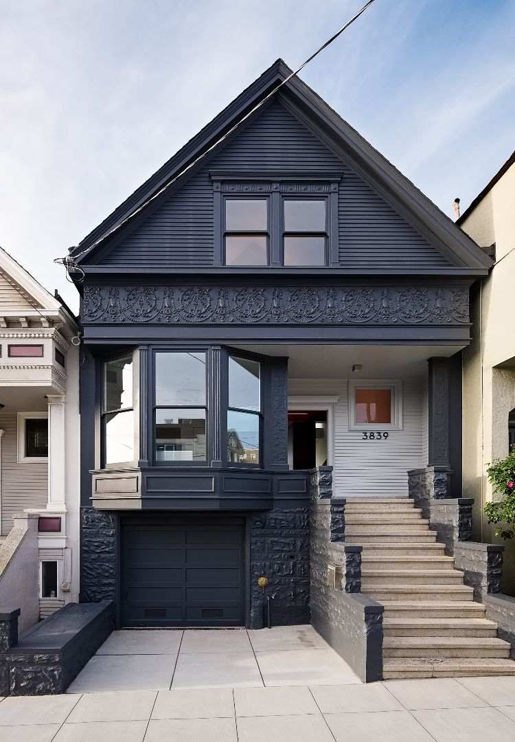 ursprungliga viktorianska hus svart fasad trappor garage gata sida