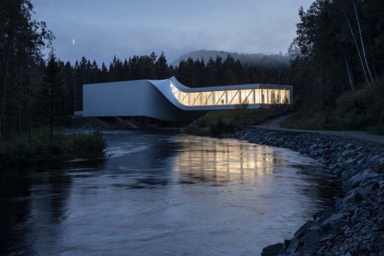 floden randselva rinner under ett modernt museum med en vriden struktur