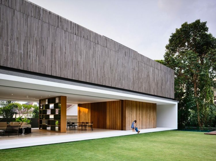 öppet vardagsrum-matplats-gräsmatta-trädgård-minimalistisk-grå-fasad