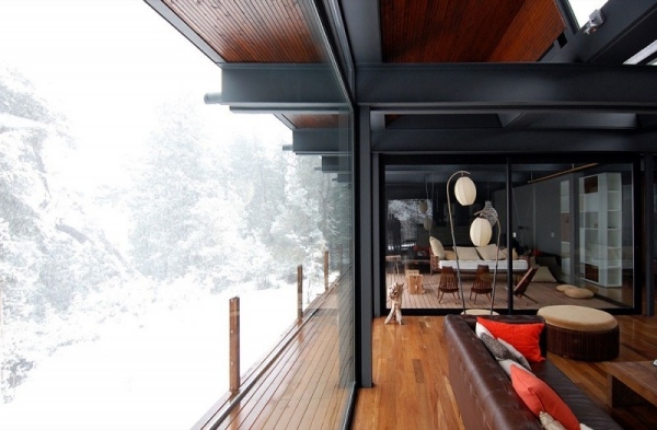 privat hus i skogen golv-till-tak-fönster vinterhus