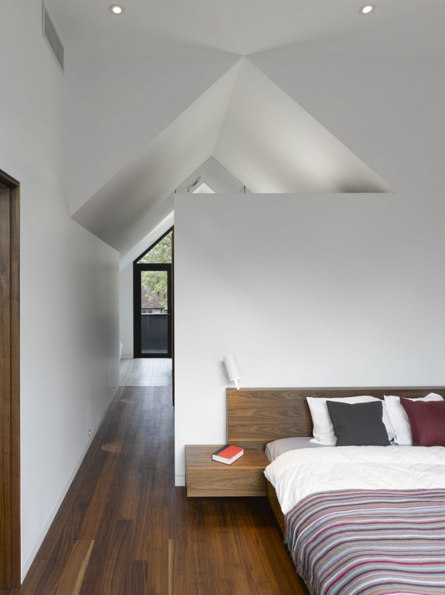 sovrum trägolv sänggavel sluttande tak vita väggar
