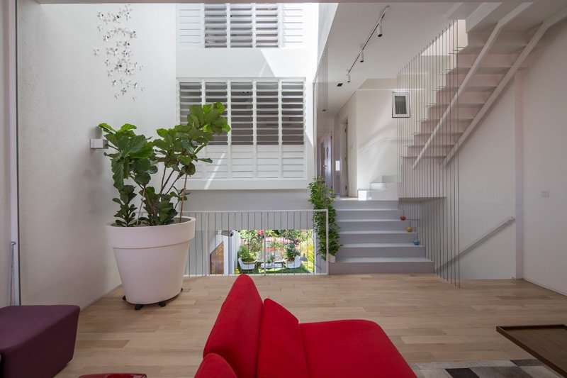 modernt-levande-öppet-vardagsrum-inomhus-trädgård-trä-golv-soffa-blomkruka-växter