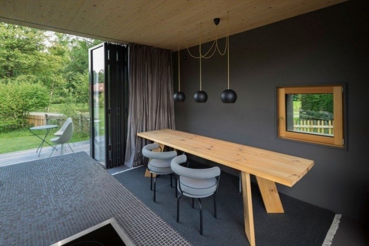 modernt-levande-litet-arkitekt-hus-matplats-matplats-bord-trä-vägg-färg-grå-trädgård-öppen