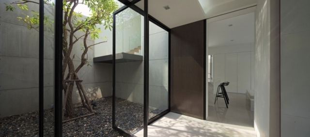modernt bostadshus thailand innergård småsten glasdörrar