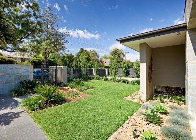 modernt bostadshus framgård gräsmatta australien grus torra växter