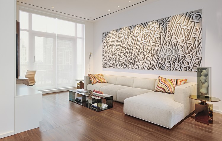 modernt vardagsrum-minimalistisk-xxl-soffa-led-tak-infällda-ljus-trä-golv-glas-soffbord