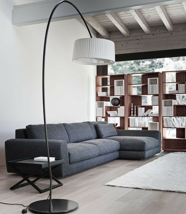 grå soffa trä vägghylla överdimensionerad vit golvlampa