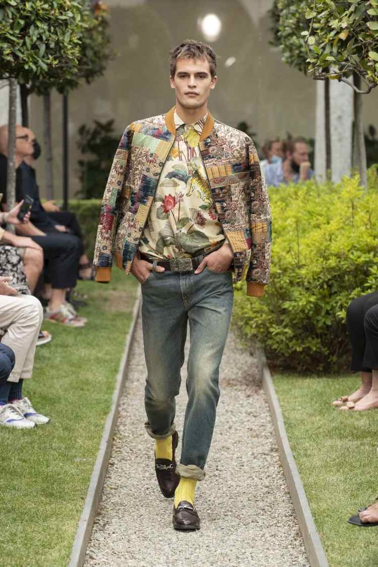 bomberjacka med blommönster och färgglad skjorta med jeans och mulor som modetrender män 2021