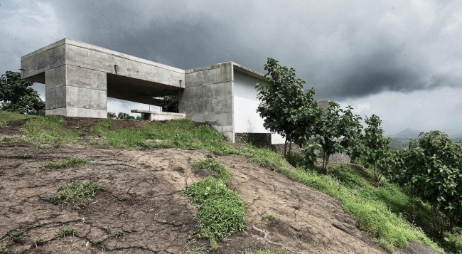 Betonghus på stenbrant sluttningsbyggd Indien-Khopoli