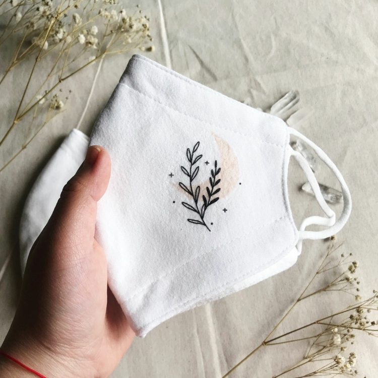 Munskydd av tyg med minimalistiskt broderi med svarta kvistar
