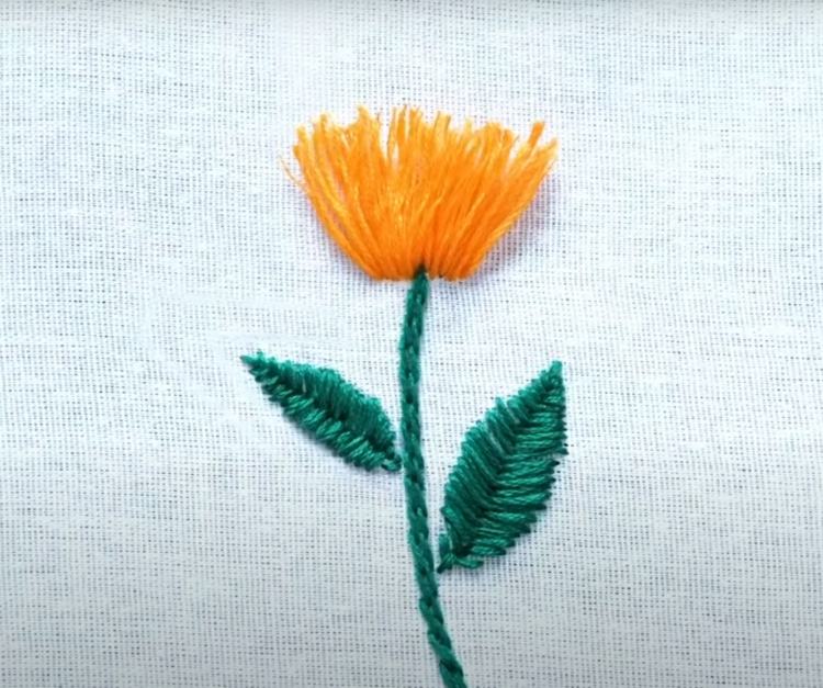 Lär dig att brodera en blomma för ett tygskydd