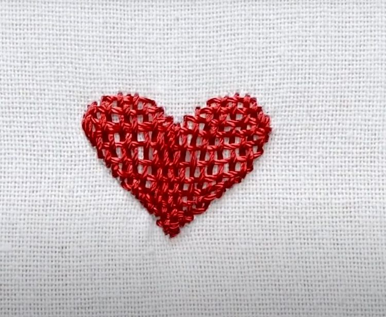 Hjärta broderat på ansiktsmask av tyg i röd färg