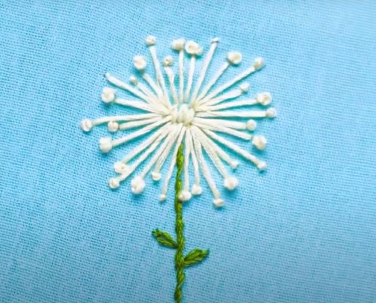 Kreativ maskros av vit och grön broderitråd