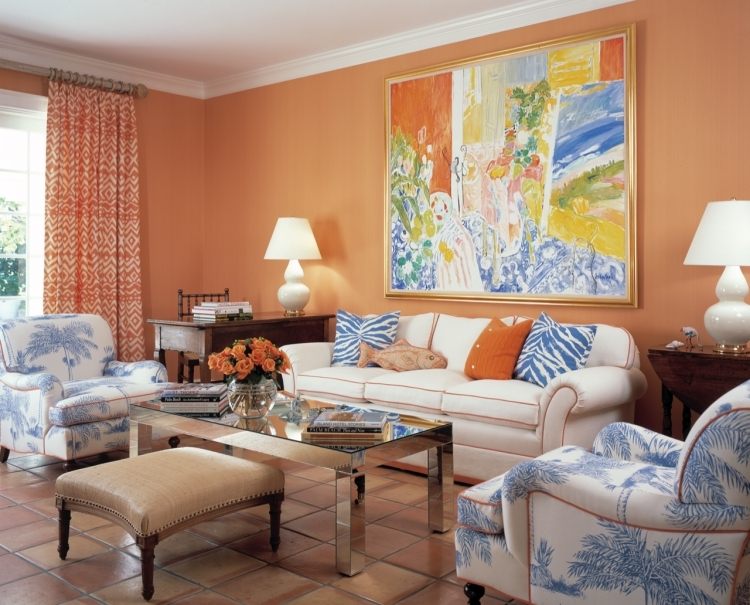 Inred vardagsrummet enligt Feng Shui -orange-bild-soffa-fåtölj-vitt-mönster-kuddar-terrakottakakel-golv