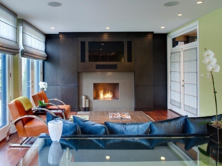 Inred vardagsrummet enligt Feng Shui -brunt-läder-fåtölj-soffa-blå-sammet-öppen spis-orkidé