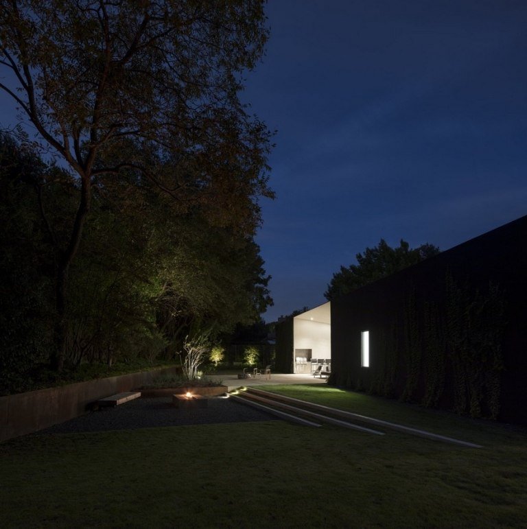 Fristående hus med gräsmatta och öppen spis i trädgården Idéer för miljövänlig belysning