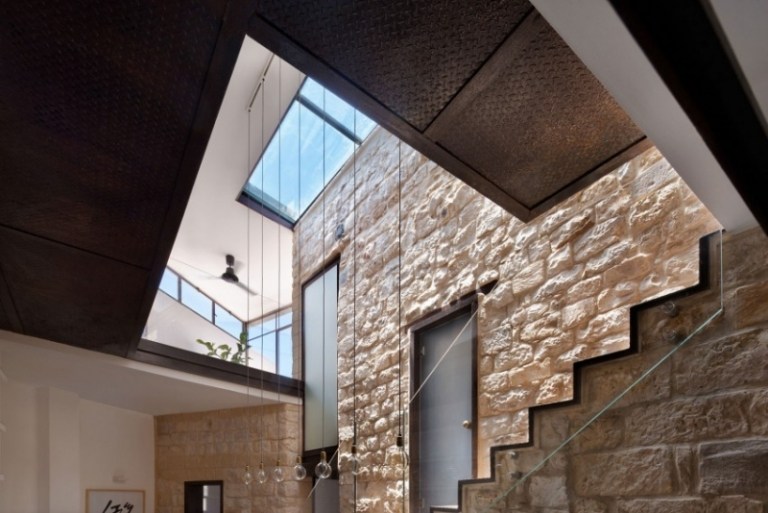 naturstenmur-inuti-utsida-murverk-takfönster-glasräcken-trappor-hängande lampor-frostat glas
