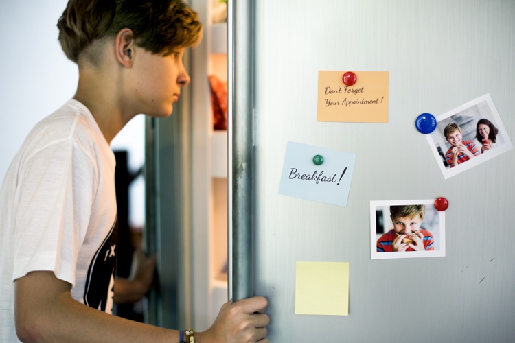 Magneter på kylskåpet innehåller anteckningar och familjefoton