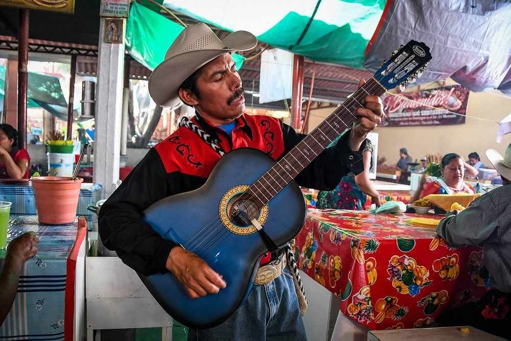 mexikansk sångare med gitarr som spelar musik i restaurangen