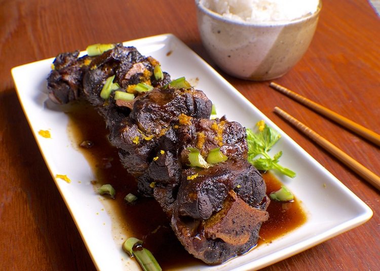 Oxtail i kinesisk stil i vit tallrik med huggpinnar
