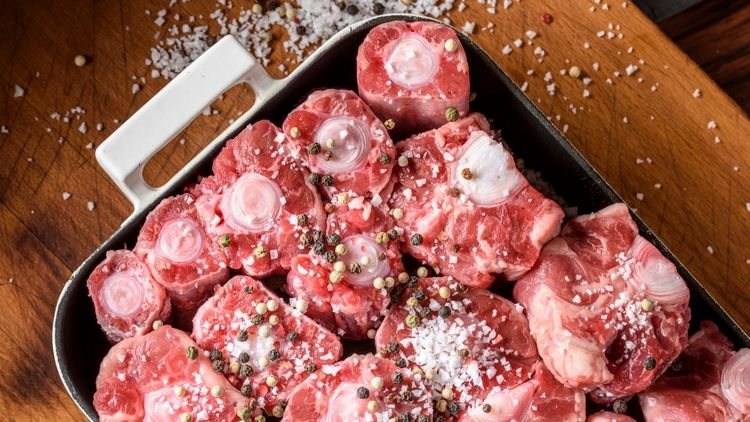 råa oxsvansar beströdda med pepparkorn och kosher salt i en grytform