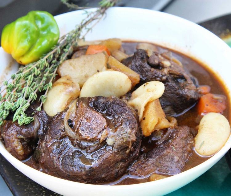 Oxtailrätt med en kvist rosmarinpaprika och potatis
