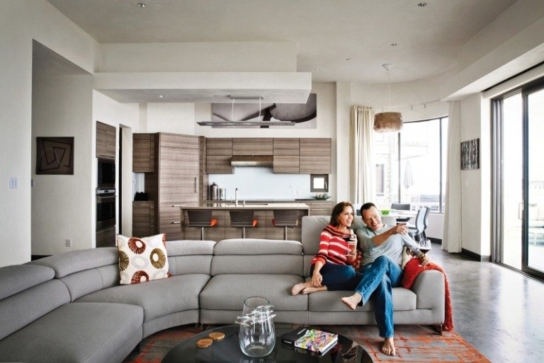 öppet-kök-vardagsrum-kök-disk-brun-grå-hörn-soffa-par-matta-accenter-fönster vägg